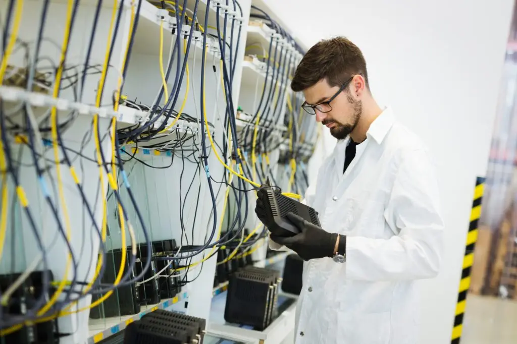 Picture of network technician testing modems in factory